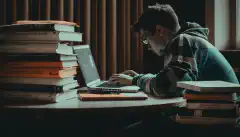 ノートパソコンと書籍を前にして勉強している人が、CompTIA Security+認定試験に合格するために必要な準備を表現しています。